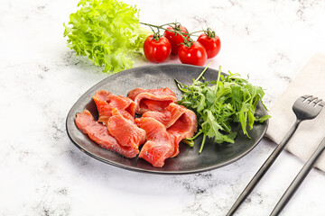 Sliced salmon with fresh arugula