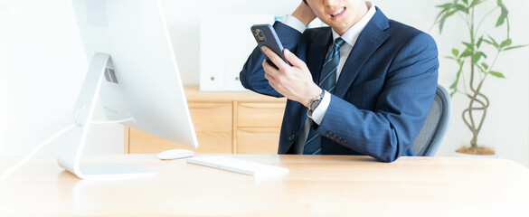 携帯を持ち落ち込むサラリーマン