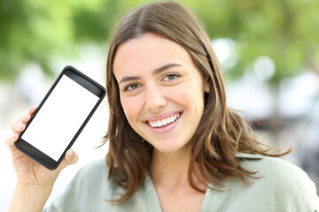 Happy woman with perfect smile showing blank phone screen