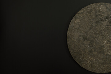 Top view of brown marble plate on black background. Food presentation, stone tray. Copy space, flat lay.
