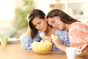 Two depressed friends eating potato chips