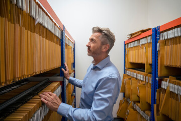 Mature businessman standing in archives storage room