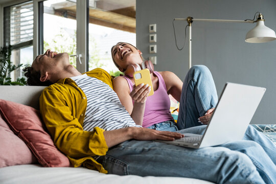 Cheerful young couple spending leisure time at home - Powered by Adobe