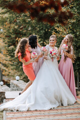 A group of women are posing for a picture, with one of them wearing a white wedding dress