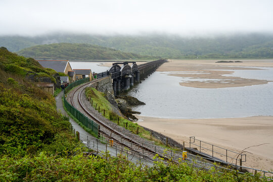 Barmouth Bridge Viaduct, a single track railway line curving out across estuary of the River Mawddach, Barmouth, Wales - Powered by Adobe