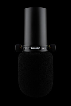 Samara, Russia - December 24, 2023: Black dynamic microphone isolated on a black background. Shure SM7B microphone close-up.