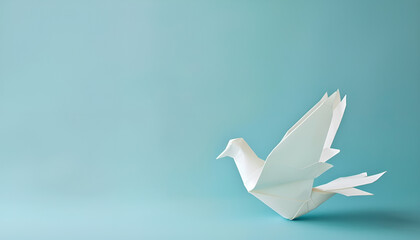 White origami pigeon on a blue paper background, peace or freedom concept, paper art work