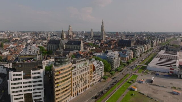Antwerp's lively cityscape features Loodswezen, the scheldt river, with cars moving along the roads and pedestrians enjoying a vibrant urban atmosphere rich in historical charm