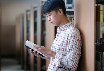 University Student Reading Book in Library