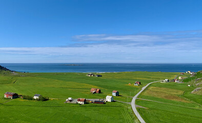 Naklejka premium Aerial view of lush green fields and road to Uttakleiv Beach, Lofoten, Norway