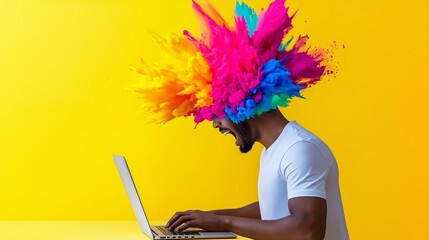 A man with a colorful explosion on his head is typing on a laptop. Concept of creativity and energy