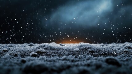 Abstract close-up view of a winter snow-covered surface under a dark, dramatic sky with falling snowflakes and a distant glow.