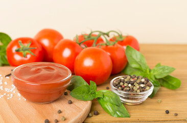 Delicious ketchup with spices and tomatoes on wooden table