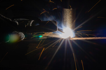 worker welding metal with sparks.
