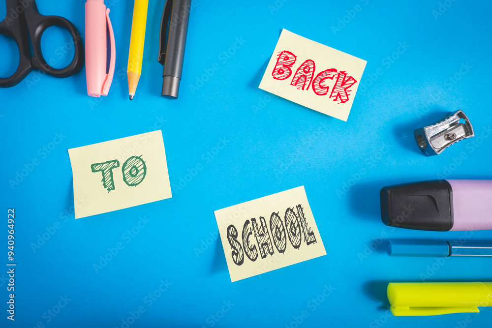 Wall mural office and school supplies on a blue background. and three sticky notes with back to school on it.