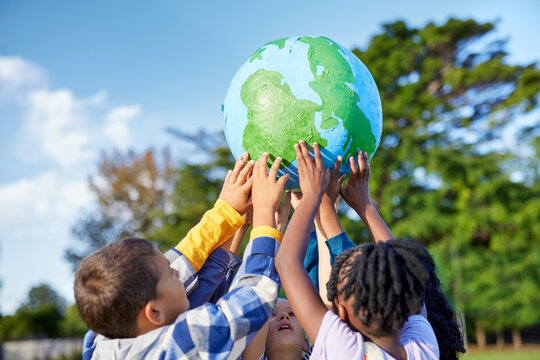 Children holding earth model for sustainable living concept