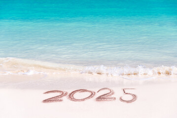 2025 written on the sand of a tropical beach, travel new year card