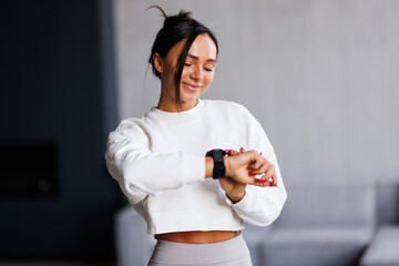 Fit woman look watch check calories use app training do exercises at home