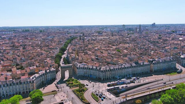 Bordeaux, France: Aerial view of famous French historic city, Roman-style stone arch Porte de Bourgogne and bridge Pont de Pierre, summer day with blue sky - landscape panorama of Europe from above
