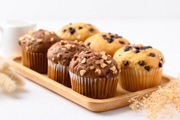 Chocolate almond muffin and Vanilla chocolate chips muffin on wooden plate