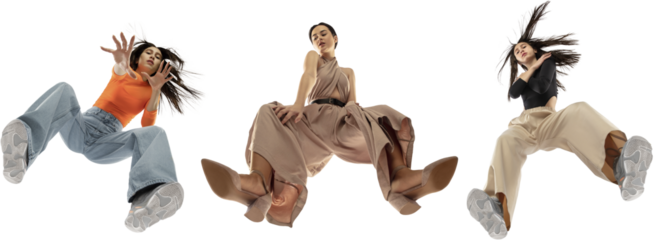 Three elegant young girls wearing diverse stylish clothes, blending streetwear and elegance, isolated on white background, shot from the bottom. Concept of fashion, youth, clothes, freedom