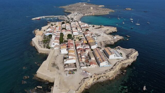 Aerial shots of Tabarca island, Spain. Sunny skies, turquoise waters, yachts anchored in the bay. Peaceful sea, vibrant city, and beach full of tourists. Costa Brava vacation spot.
