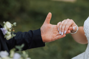 A man and woman are holding hands, with the woman wearing a wedding ring. Concept of love and commitment between the couple