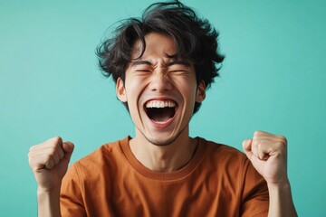 ガッツポーズをして喜ぶ若い日本人の男性（ワールドカップ・試合・達成・勝利・歓喜・勝負）