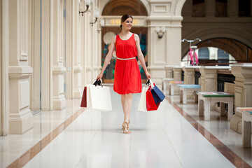 Young brunette woman with some shopping bags in the mall