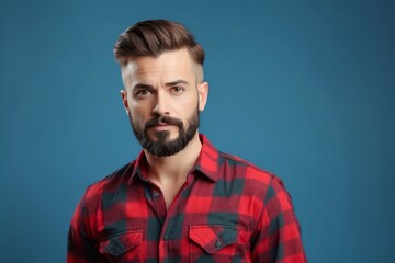 Fototapeta premium Close-up portrait of a young man with a beard wearing a red and black plaid shirt