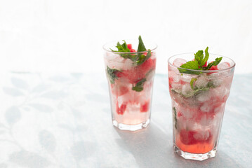 Homemade summer watermelon lemonade with ice and mint on light background, place for text