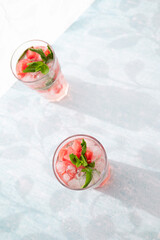 Homemade summer watermelon lemonade with ice and mint on light background, place for text