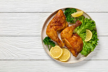 fried chicken legs with lettuce, lemon on plate