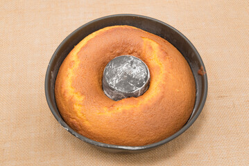 Traditional and delicious homemade Brazilian carrot cake in the pan. Isolated on jute background