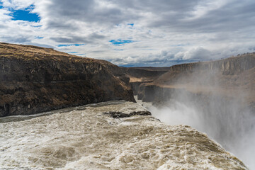 Water cascades over gullfoss waterfalls on a cloudy day in Iceland at the golden circle in Mai