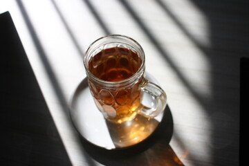 A glass of tea with the strip shadow from the window light.