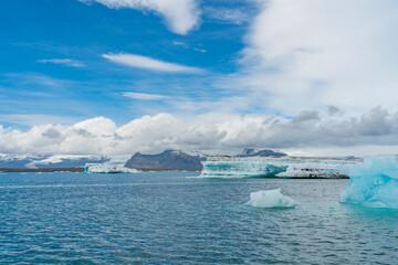 Joekulsarlon Glacier Lagoon Landscape with blue ice at south Iceland, background a mountain range with snow