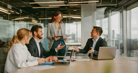 A collaborative business meeting involving professionals who are actively engaged in discussion and...