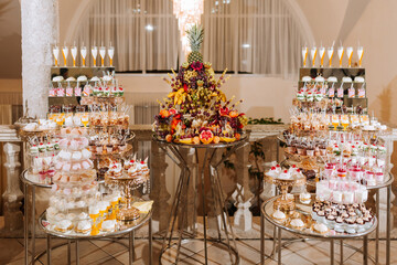 A table with a variety of desserts and fruit, including a pineapple