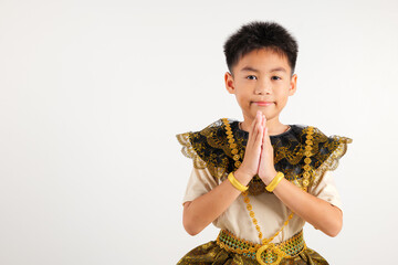 Portrait of Thailand kid boy smiling traditional Thai dress costume posing to pay respect in studio...