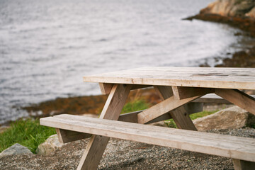 Bench on rocky cliff with scenic water and mountain view