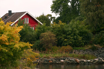 Obraz premium Traditional red wooden house with white framed windows