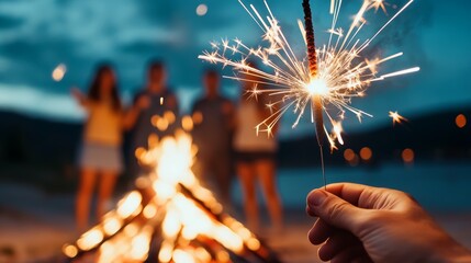 Friends laugh and celebrate with sparklers while fireworks light up the night sky and a bonfire crackles