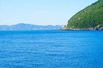 Fototapeta premium View of the coast from a ship from afar on a Sunny day