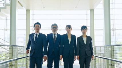 Fototapeta premium ロビーを歩く幅広い世代のビジネスパーソンのグループ