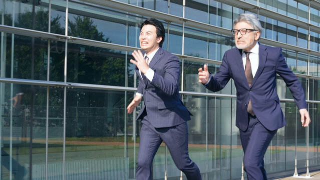 二人で走るスーツの男性