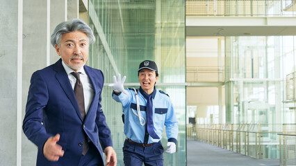 警備員に追いかけられるミドル男性ビジネスパーソン