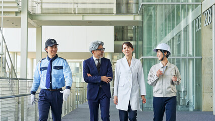 ロビーを歩く様々な職業の人々（ビジネスマン・エンジニア・研究者・警備員）