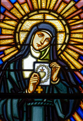 Fototapeta premium Stained glass window of Saint Marguerite Mary Alacoque showing her drawing of the Sacred Heart of Jesus. Vitrail de Sainte Marguerite Marie Alacoque montrant son dessein du Sacré Coeur de Jésus. 