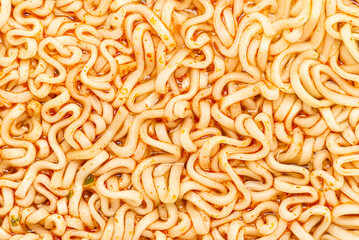 Close up real boiled instant noodles in the spicy soup background.